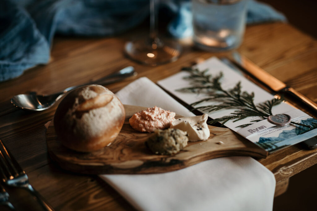 Fresh Bread and Cultured butters on a wooden board for a personalized placesetting at a Rossland, BC Wedding at the slope-side Josie Hotel.